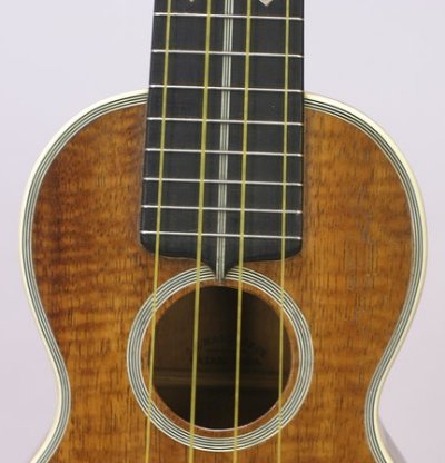 The ebony fingerboard has three fine white stripes characteristic of 